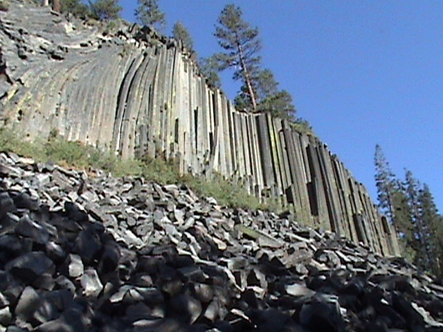 large rock formation and vegetation on the side of a hill