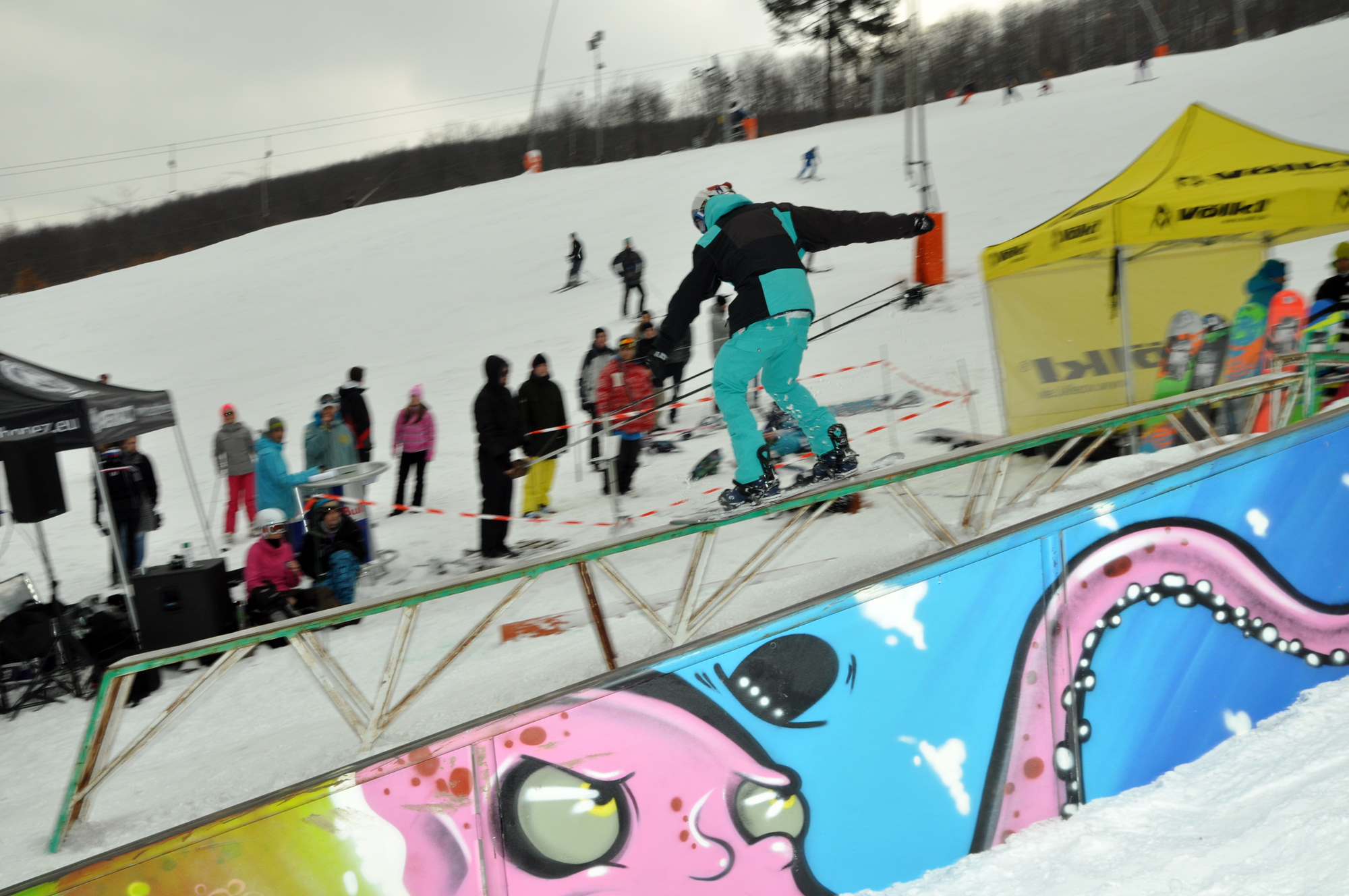 a person riding skis on a rail at a snow resort