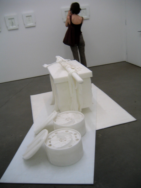 a woman takes a po of a sculpture at an art exhibition