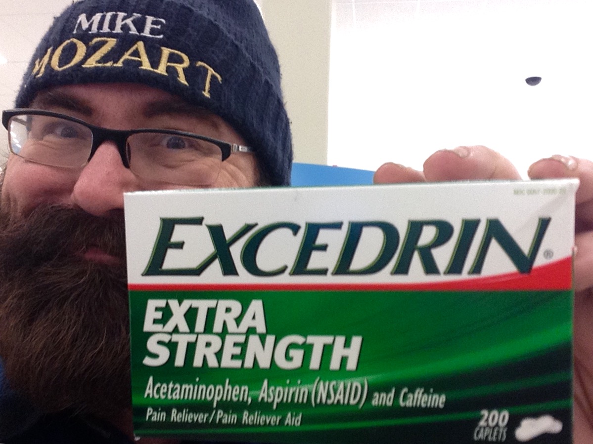 a man in glasses holds a tube of extra strength