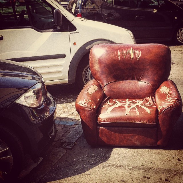 a leather chair painted with giraffes sits next to other cars