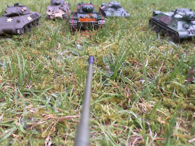 several toy tanks are laying in the grass