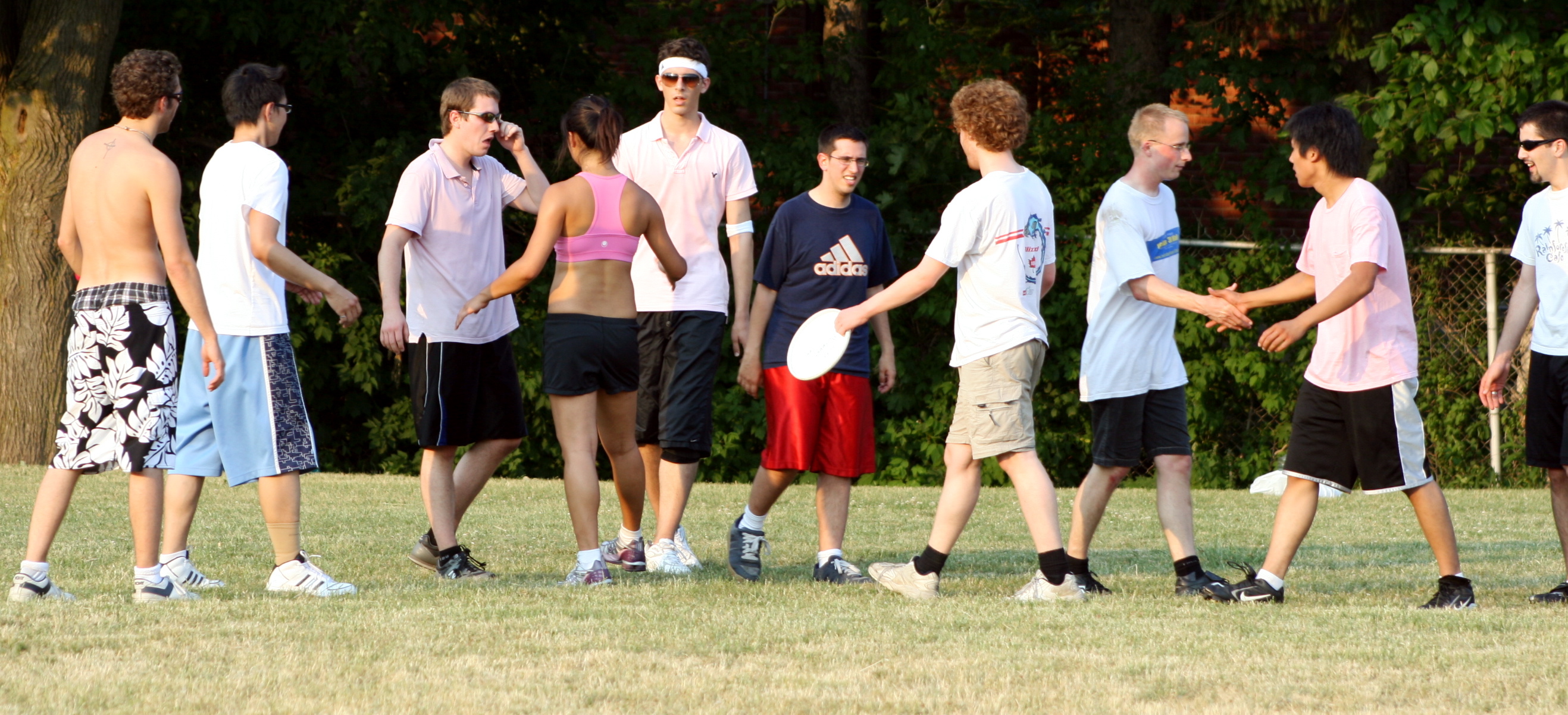 several men with frisbees standing in a field