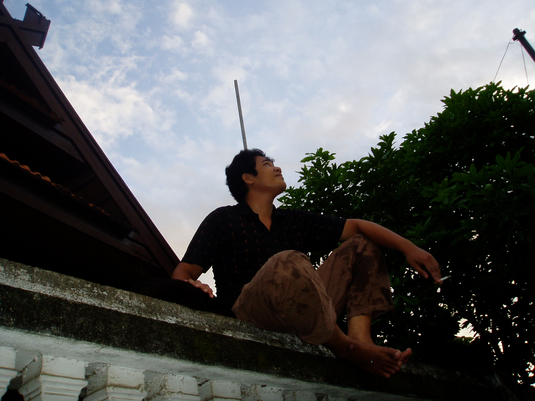 a man on a building looking up into the sky