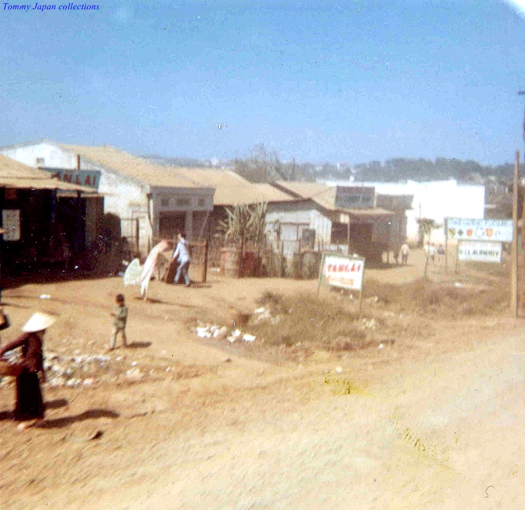 people standing around an old dirt and slum village