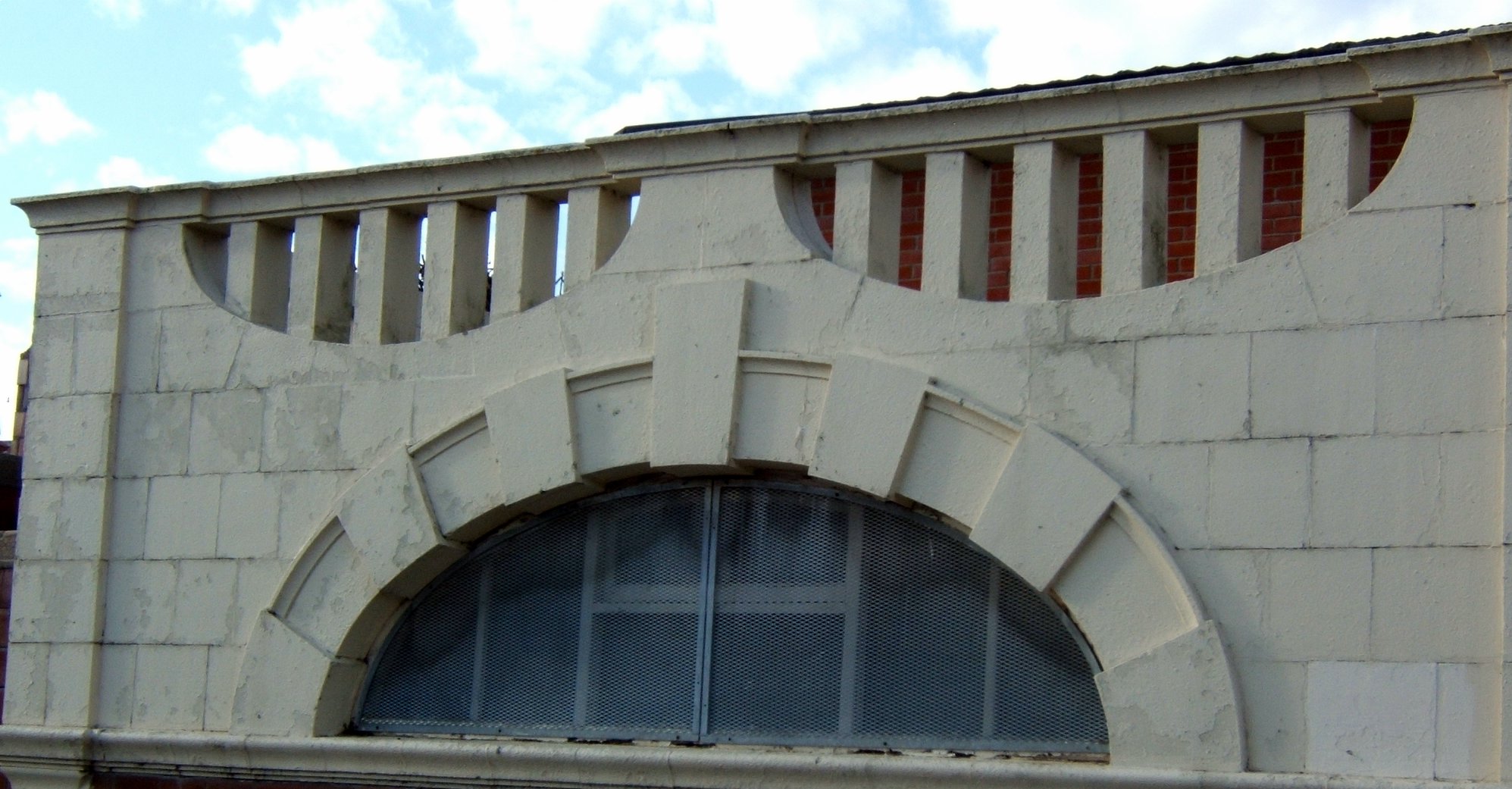 an arched window in an old white brick building