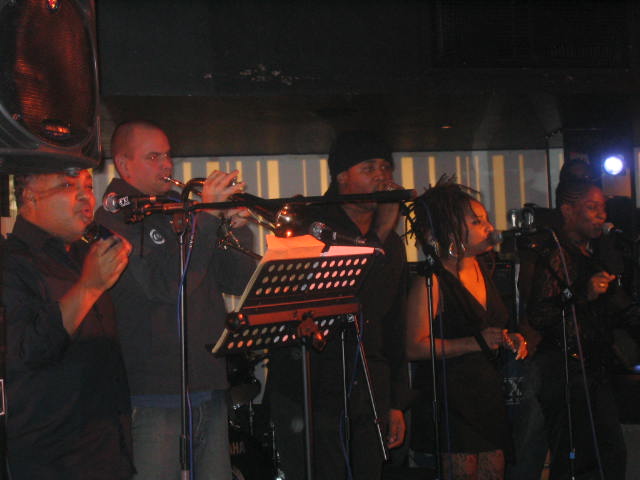 a group of musicians playing instruments in a bar