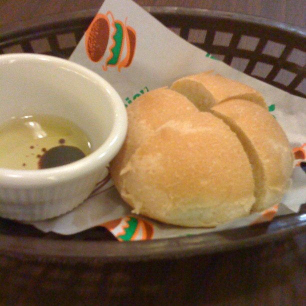 a bowl containing an oil and two small sandwiches