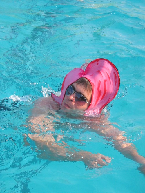 a woman swimming in a pool wearing a life jacket