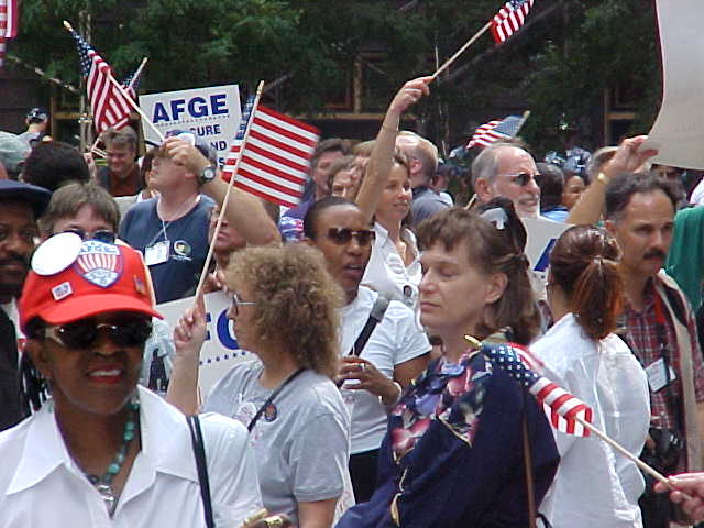 a crowd of people that are standing with american flags