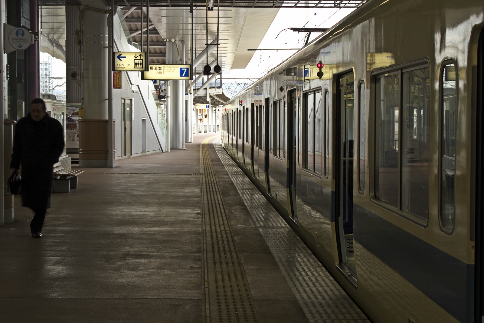 the man is walking down the train platform