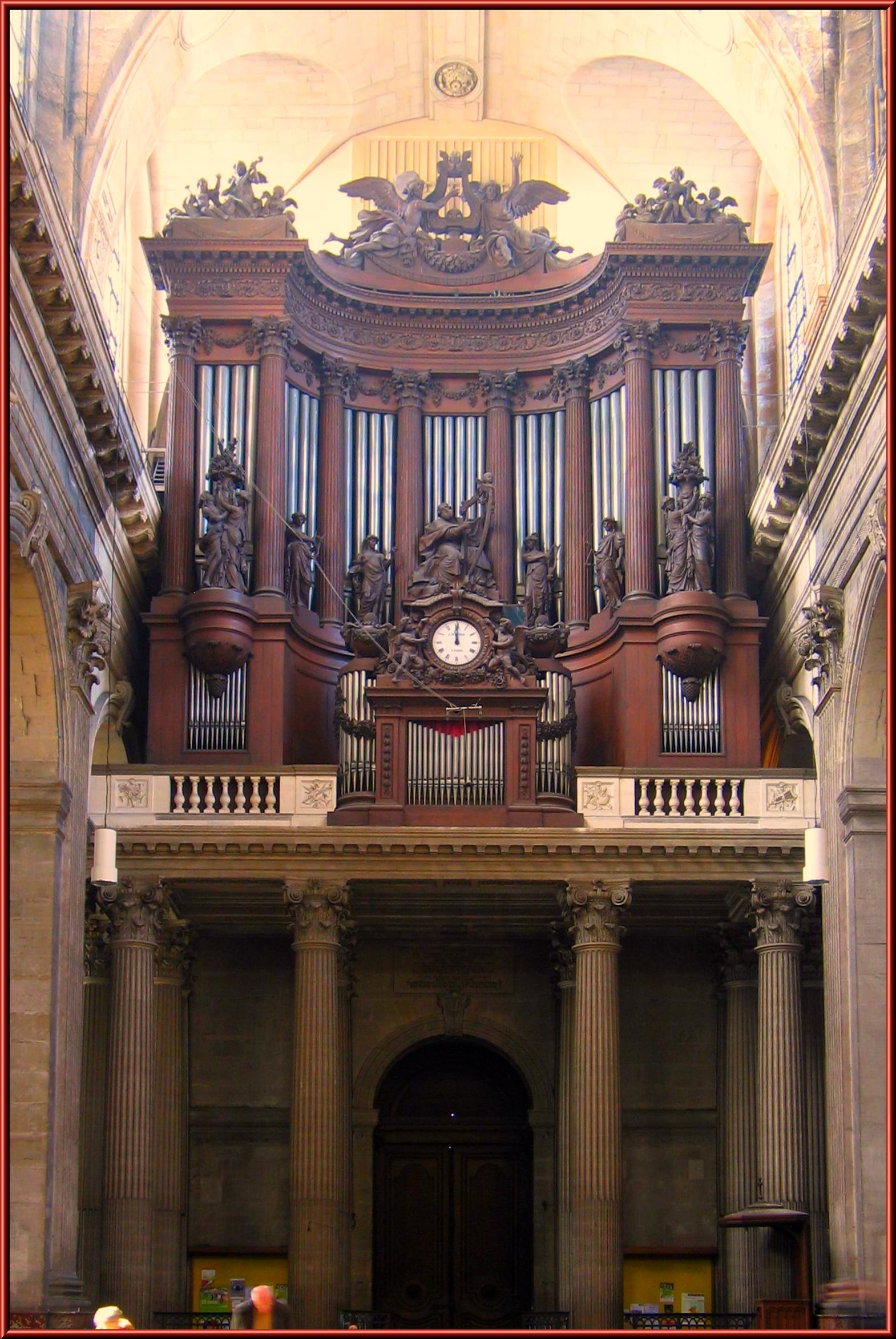 an elaborate organ sits on the far end of a balcony