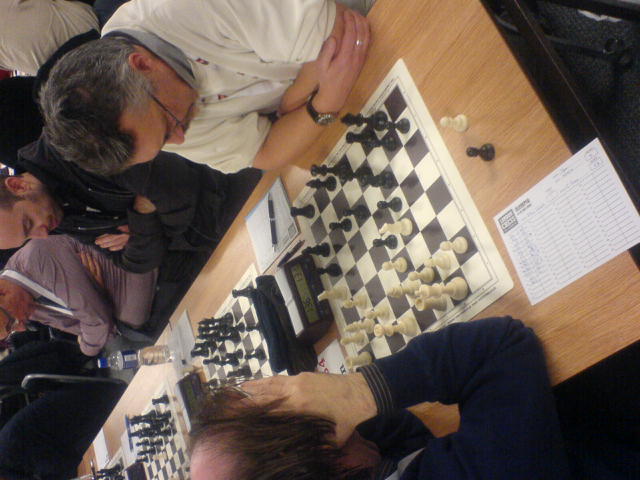 the man is sitting at a table playing chess