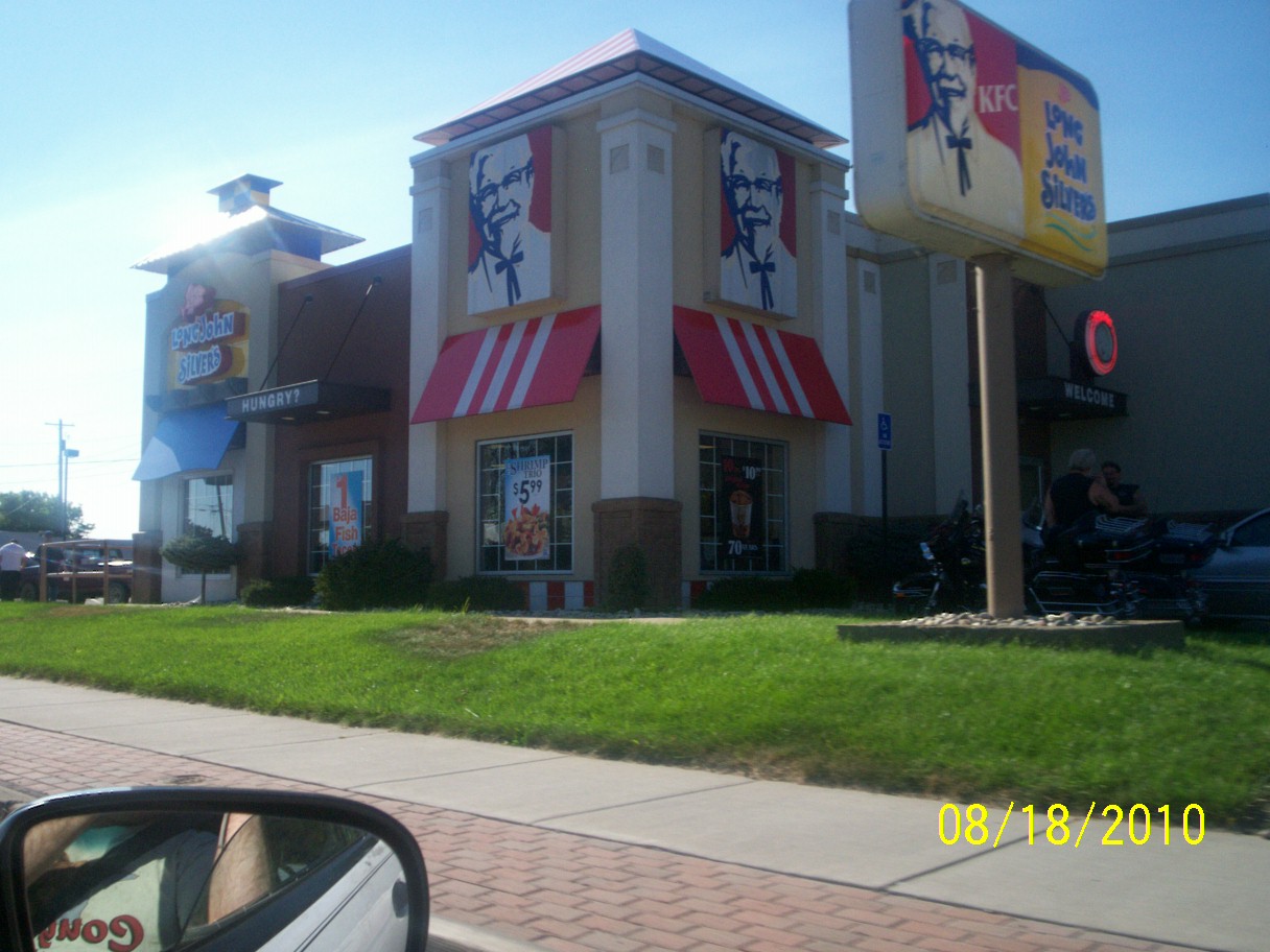 the corner in front of the chinese restaurant has grass in it