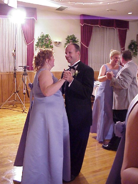 a woman wearing a gown standing next to a man