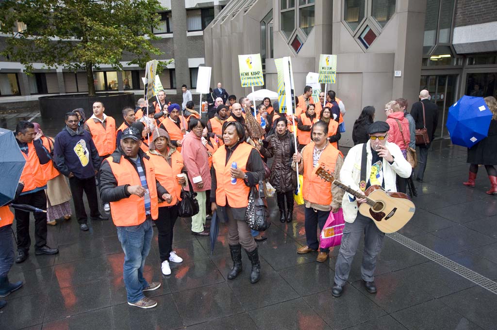 some people in orange shirts with signs and a guitar