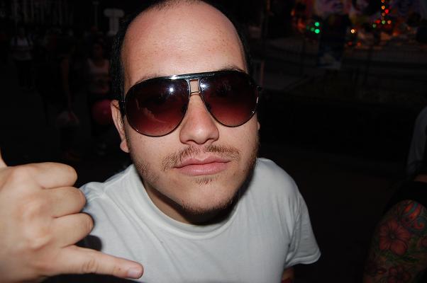 a man in sunglasses wearing a white shirt is pointing