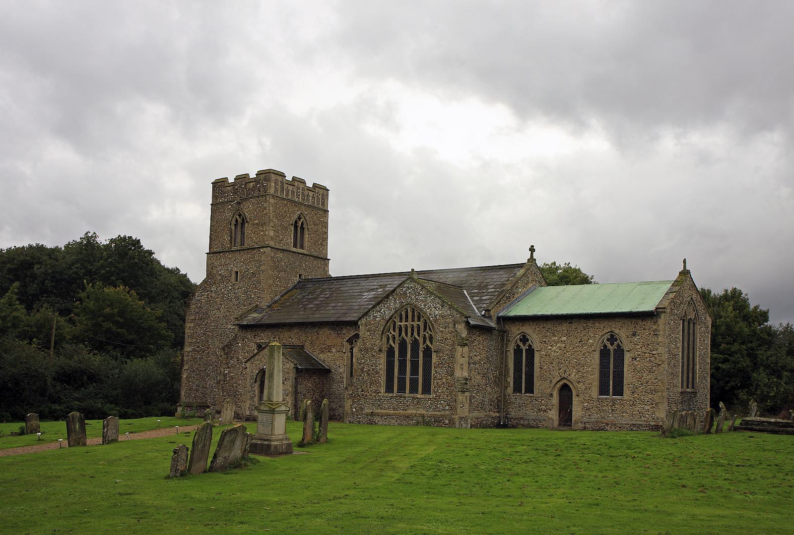 an old church with a tall green roof sitting on the grass