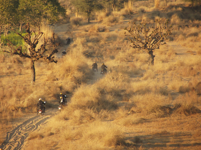 motorcyclists and dirtbikes riding down a road