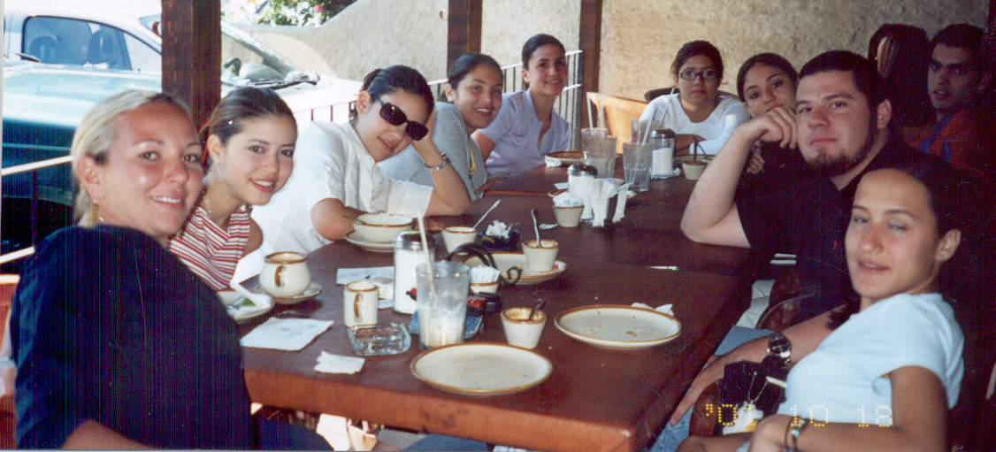 a group of people smile as they sit at a dining table