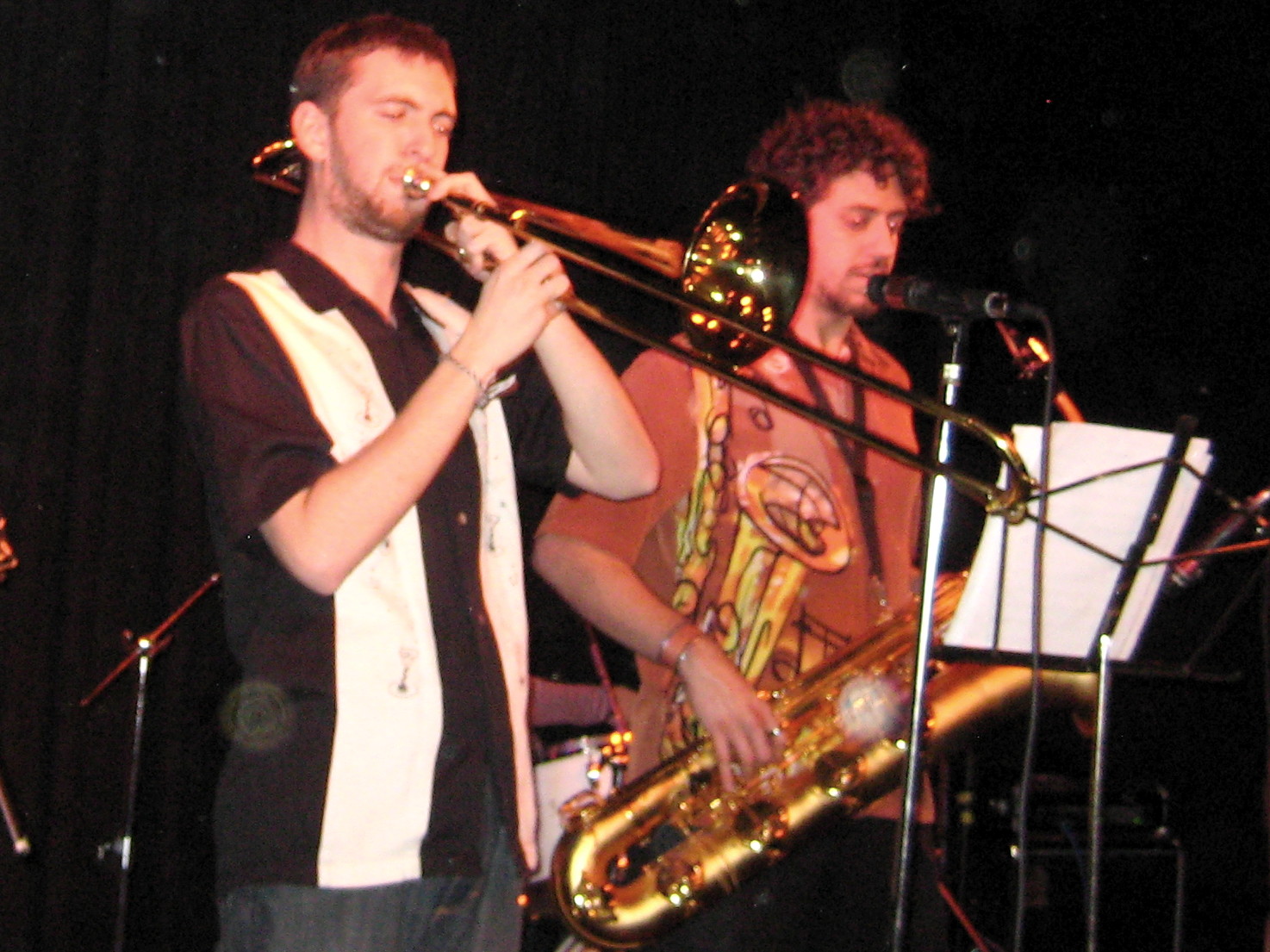 three musicians are singing with a trumpet and a trombone