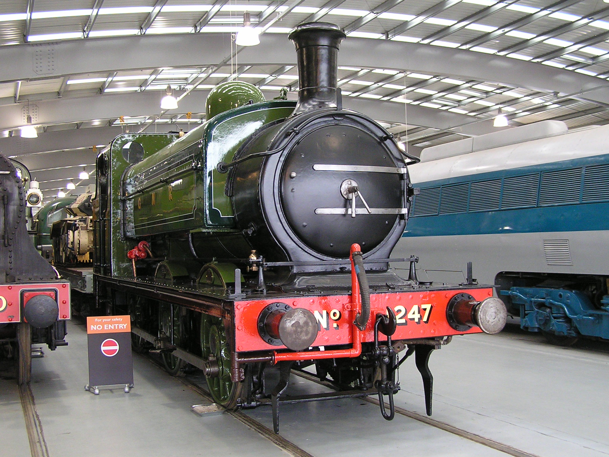 the steam engine is next to the train on the track