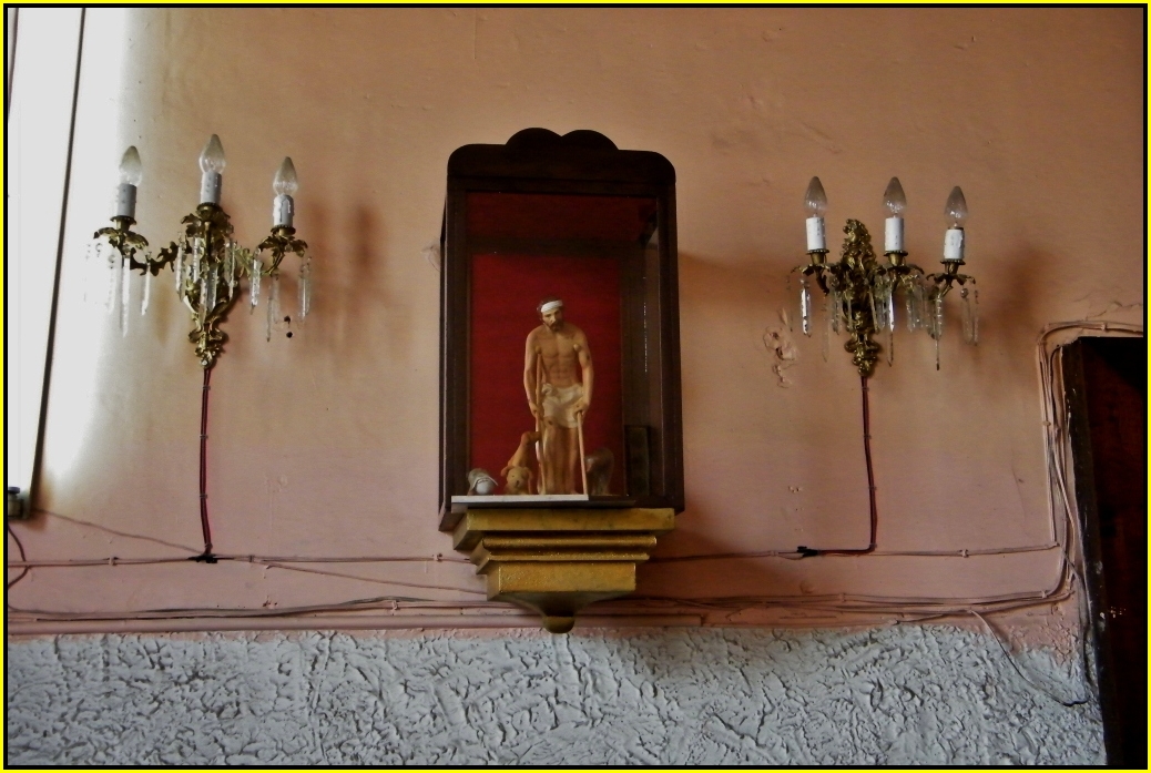 a fancyly decorated fireplace mantle and wall light with statues