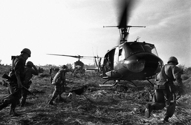 soldiers getting ready to leave a helicopter and other people