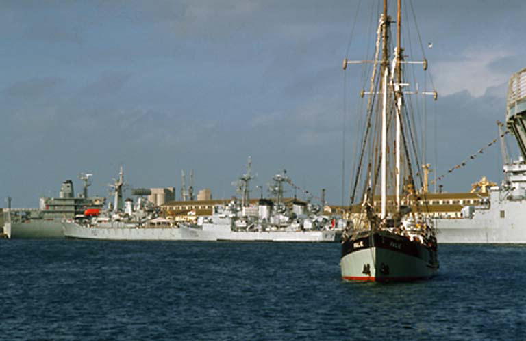 ships and military aircraft in harbor area with blue sky