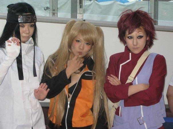 five people posing in costumes at a convention