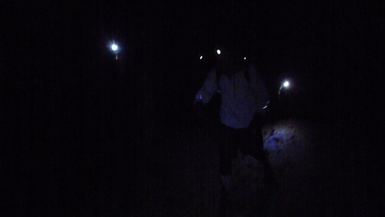 two people standing in the dark looking at soing
