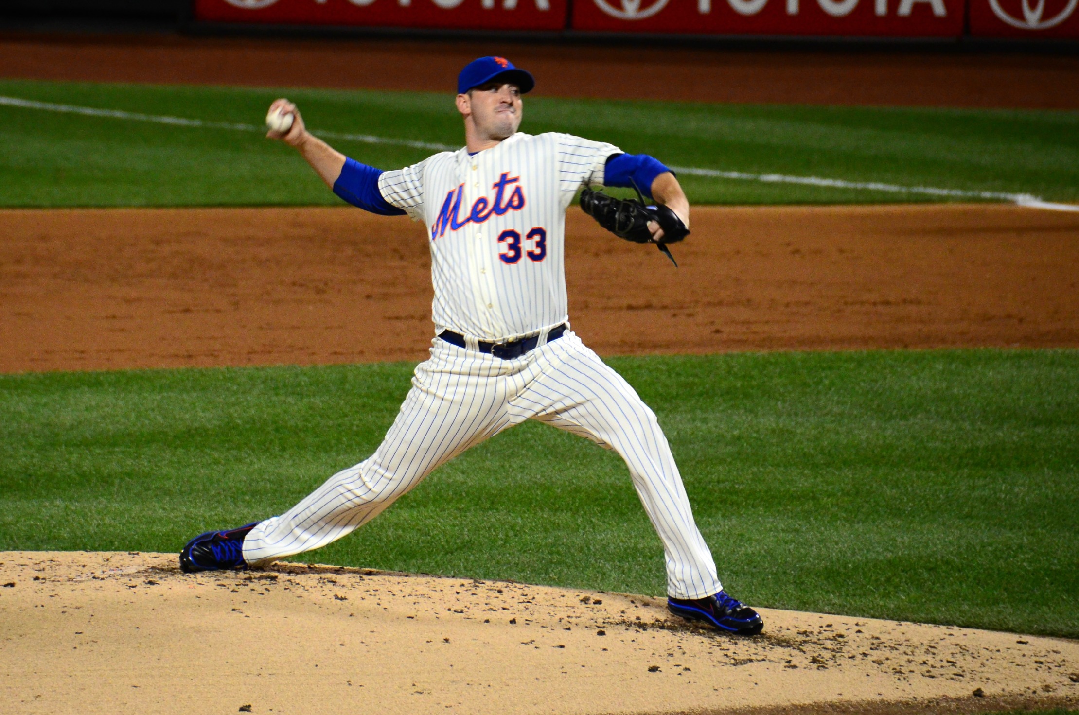 a pitcher in a mets baseball game gets ready to throw the ball
