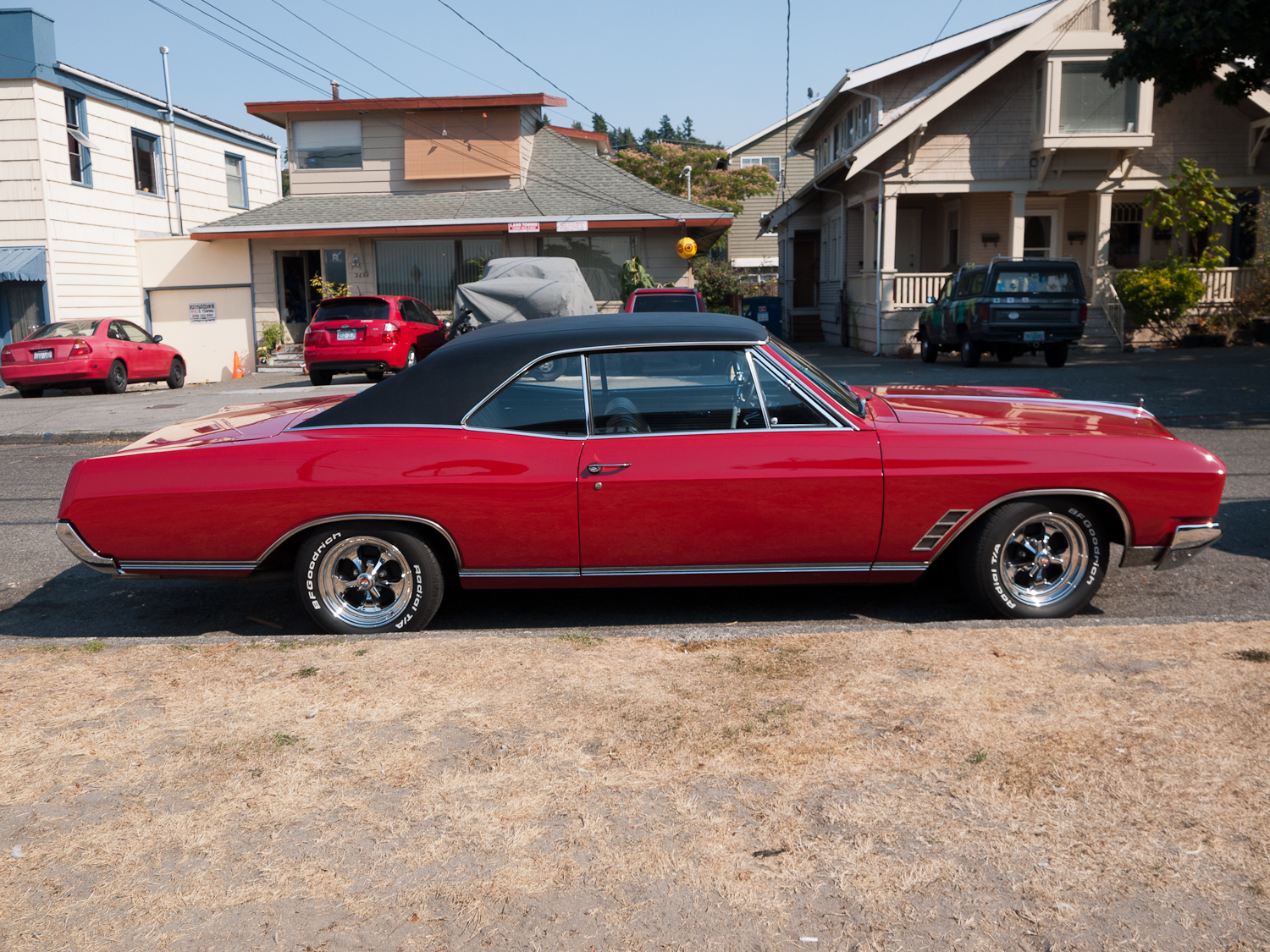 a red muscle car parked in a parking lot