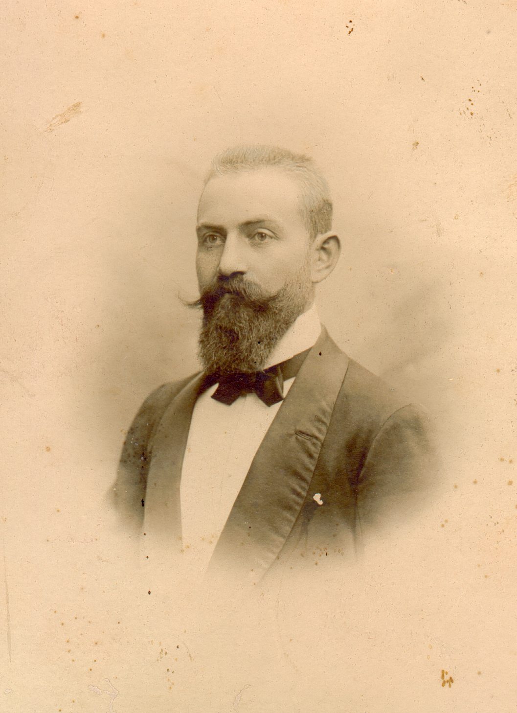 an old pograph of a man with a beard and a suit