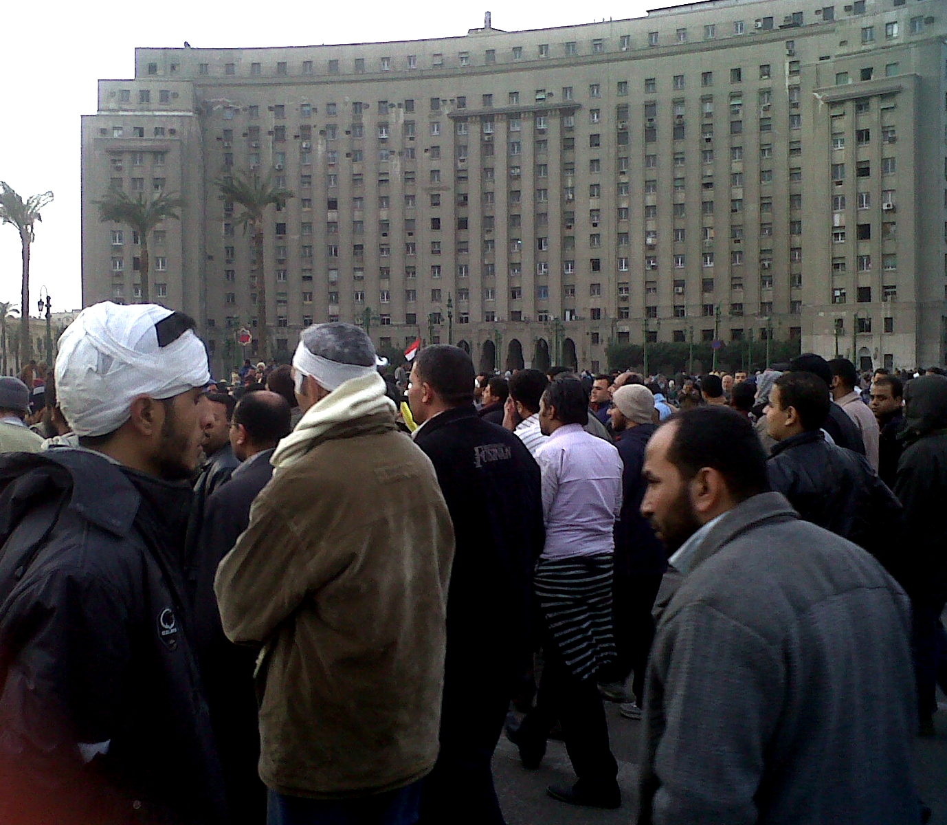 the crowd of people are outside the large building