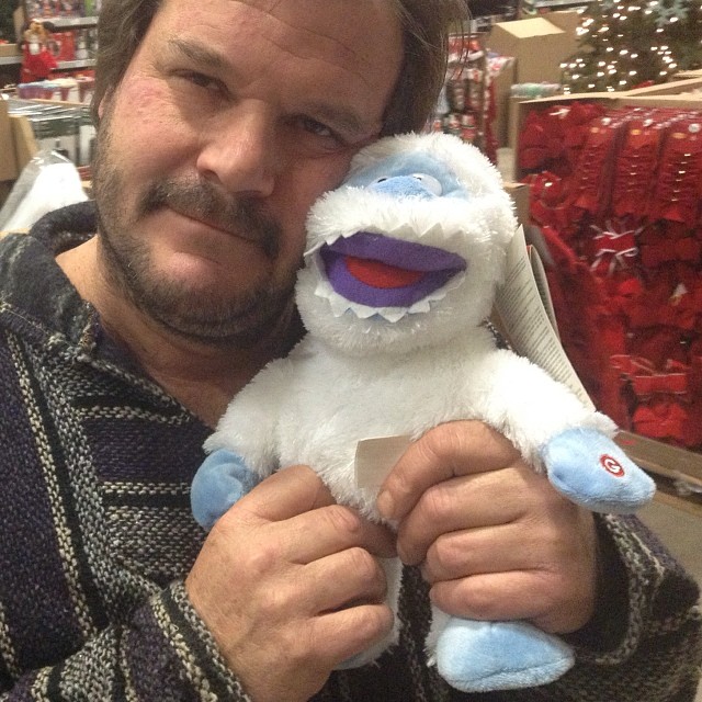 a man with a beard holding a stuffed animal
