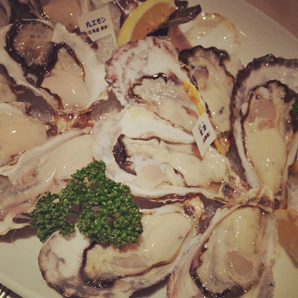 several different types of oysters with lemon wedges