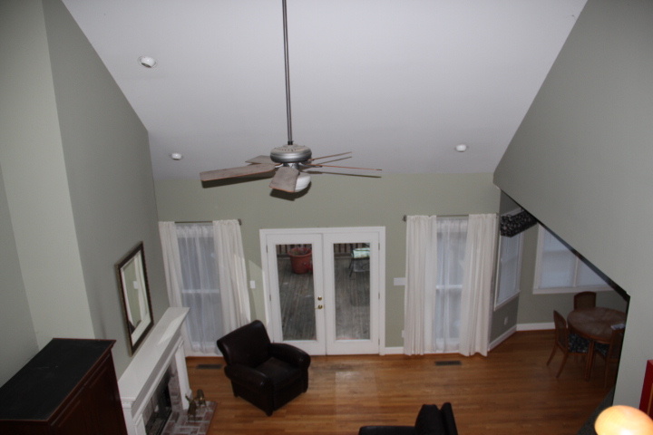 a room that has a ceiling fan, and a black chair in it