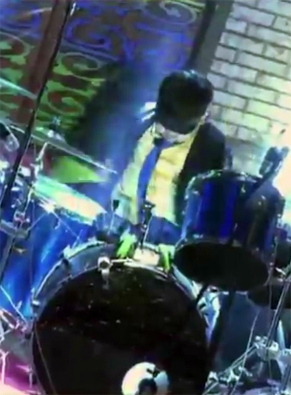 a man is sitting on stage playing drums