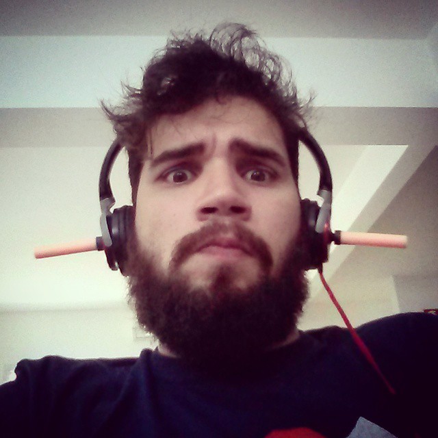 man with beard wearing headphones, staring ahead