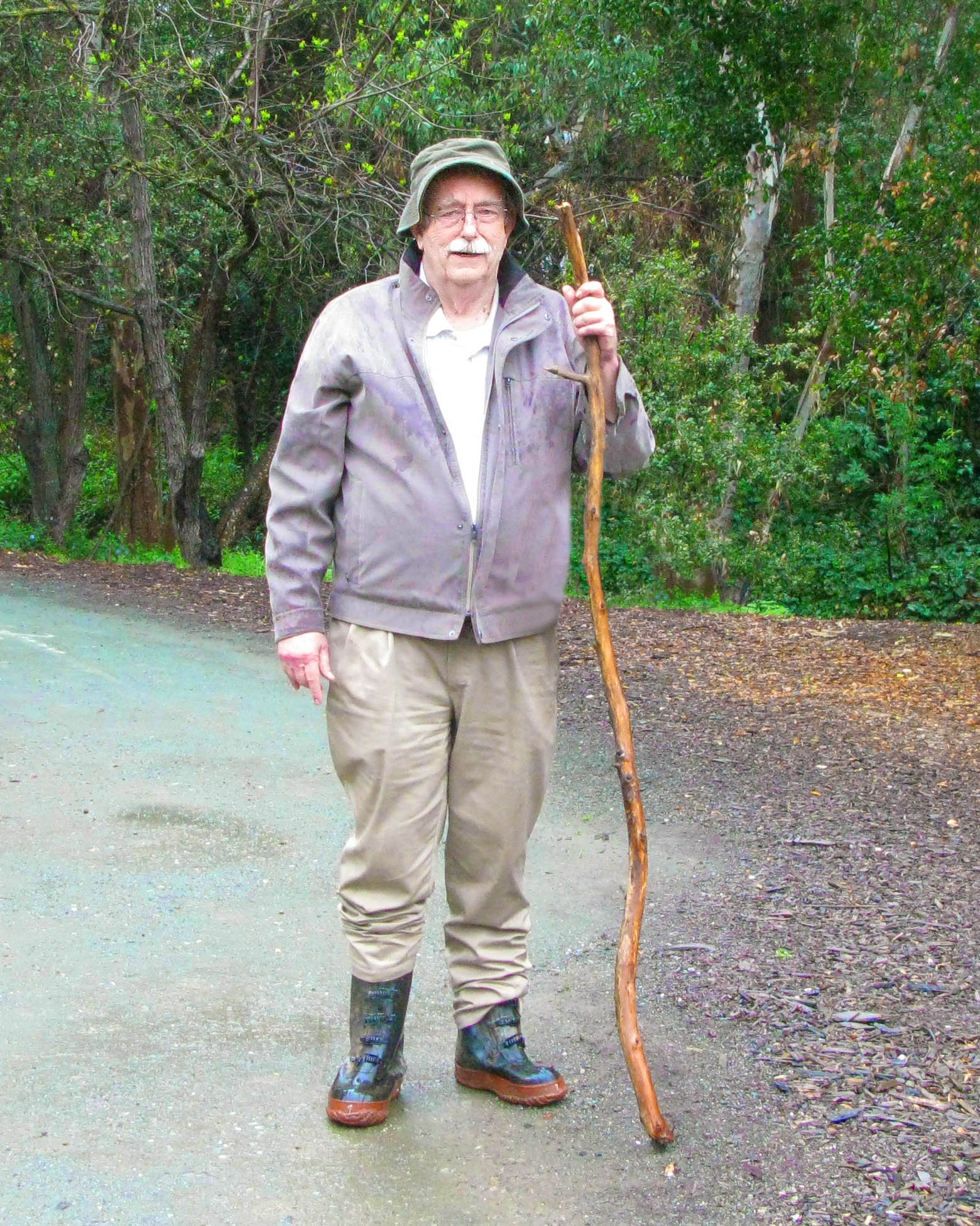 the old man is posing with a long stick