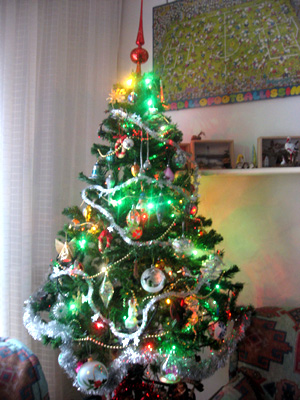 a brightly colored christmas tree sits in the corner