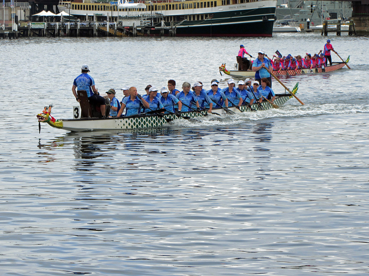 a team of people rowing on a long boat