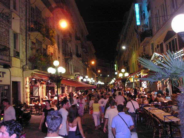 a city street filled with lots of people at night