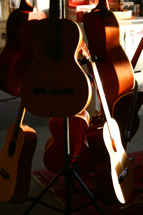 two guitar guitars leaning against each other on a tripod
