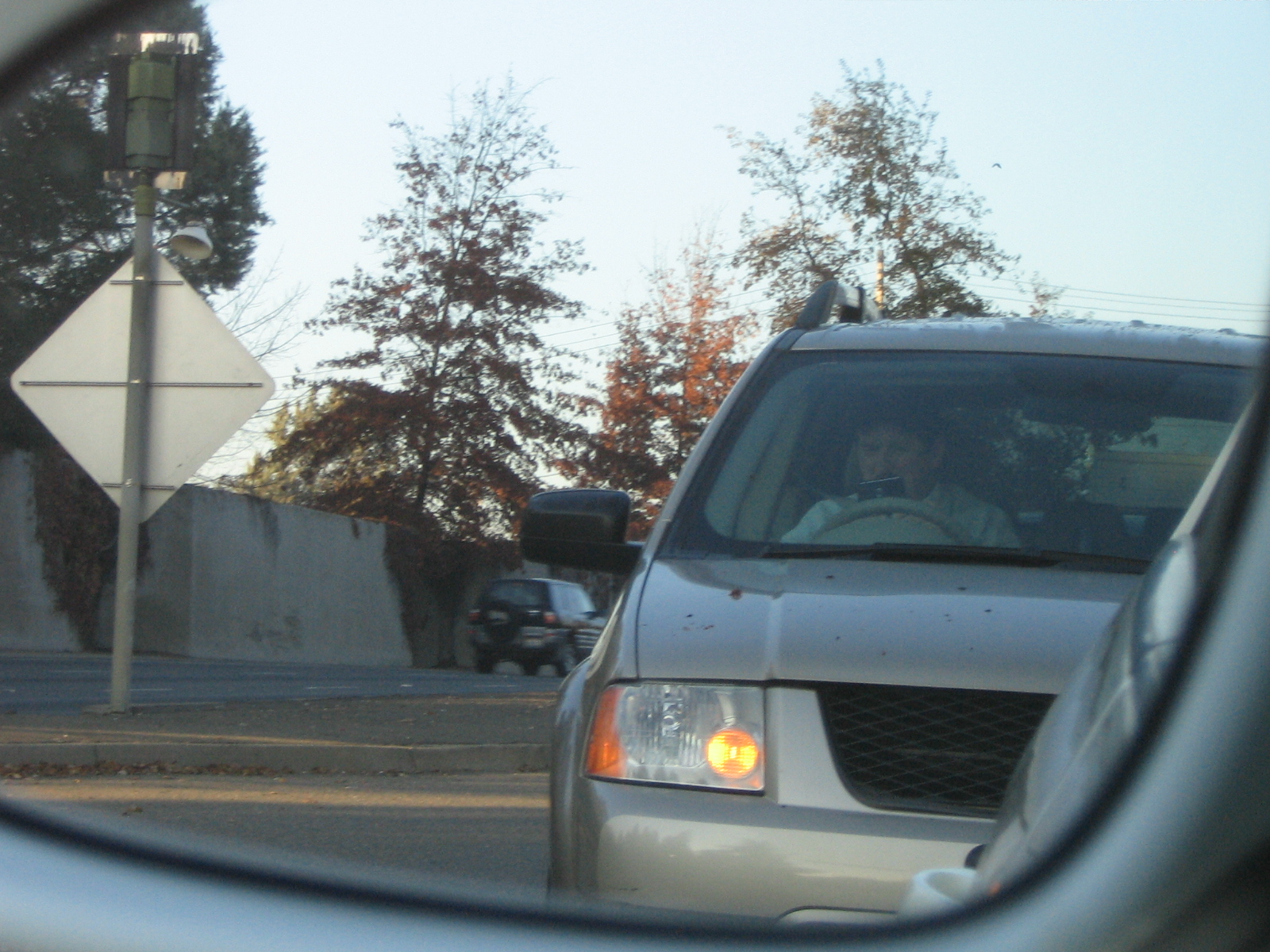 the reflection of a person behind a car's rear view mirror