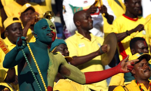 a group of men in yellow and red with painted faces