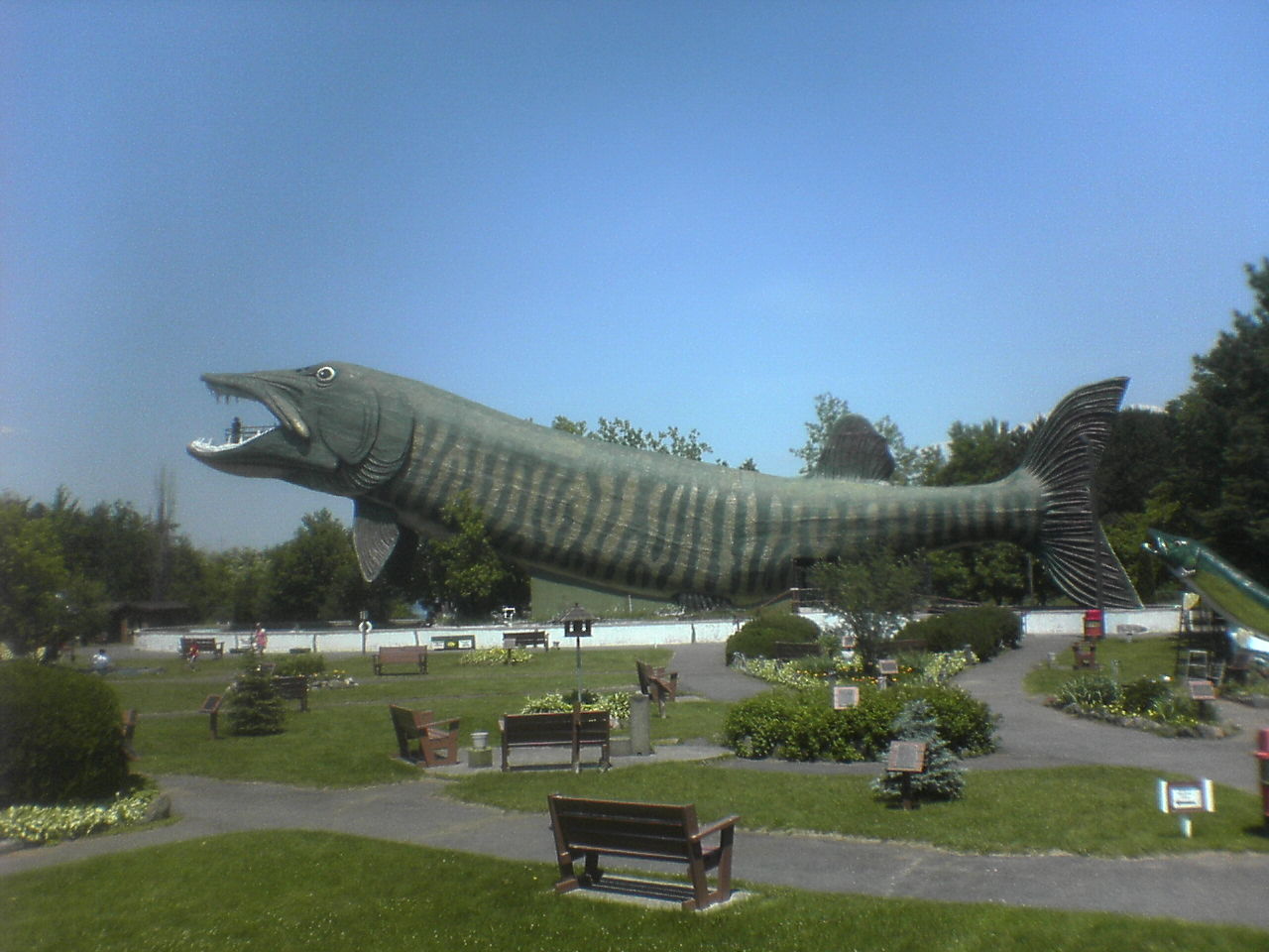 a giant fish statue in a park on the lawn