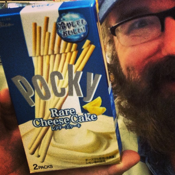 a man holds a box of rock's rare cheese cake