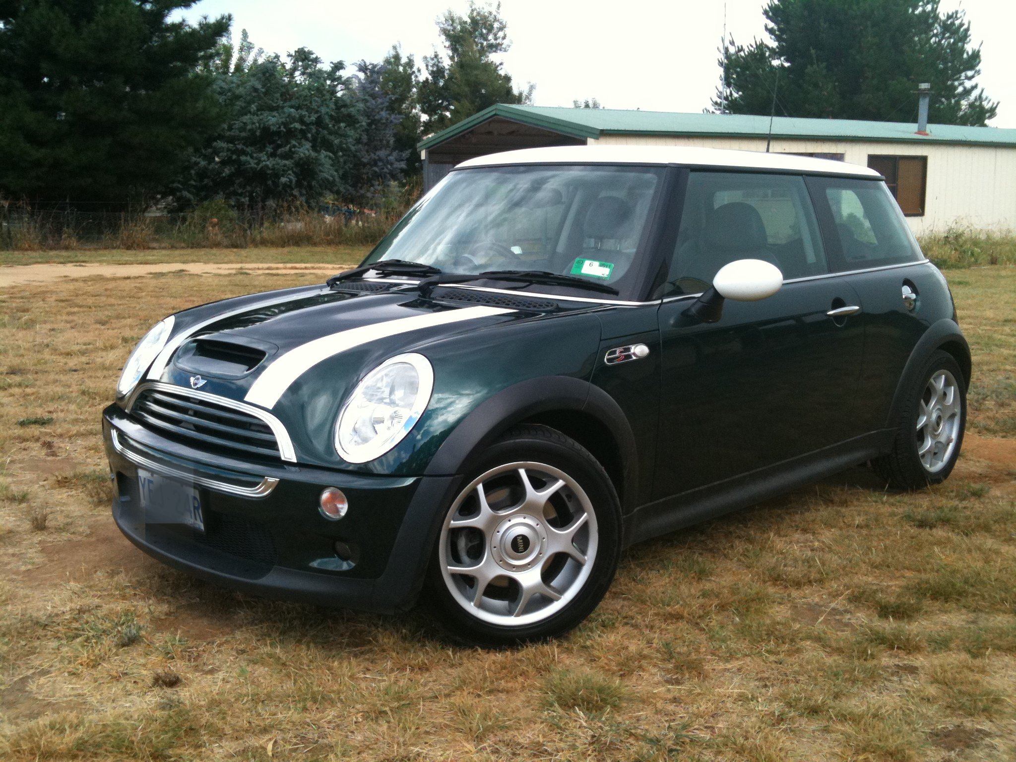 a black car parked on the ground in a grassy field